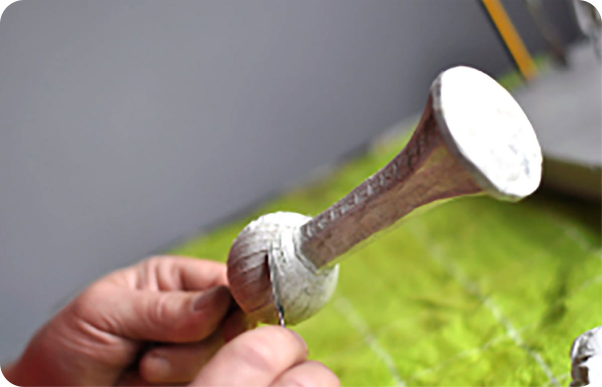Artisan forming a detailed mold from the clay sculpture