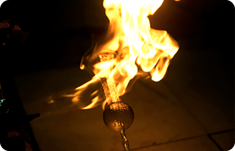 Glassblower shaping molten glass for the ornament