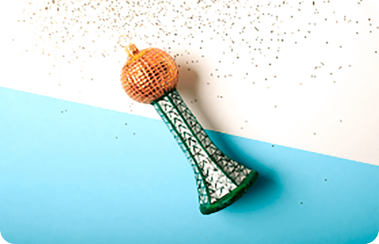 Artisan applying glitter as the ornament's finishing touch